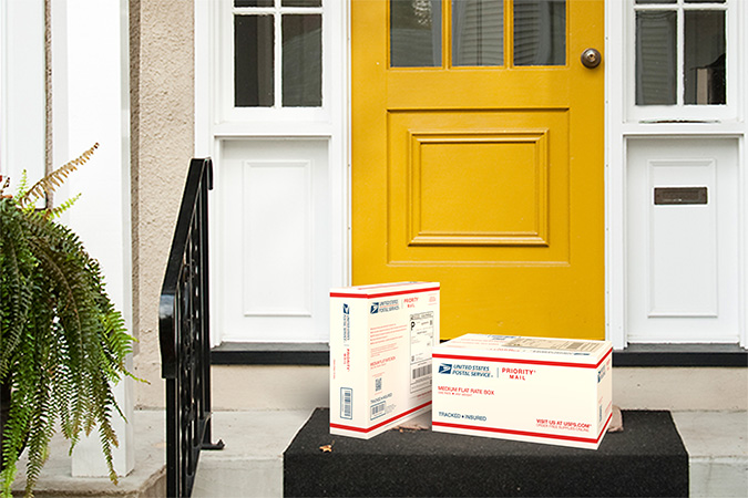 Two Priority Mail packages on a doorstep ready for pickup.