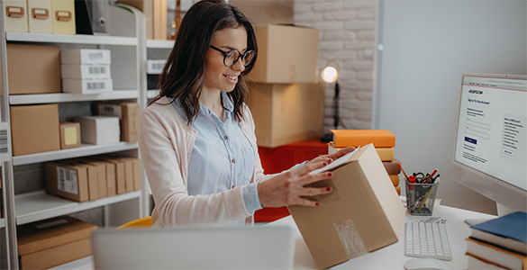 Person examining shipping boxes.