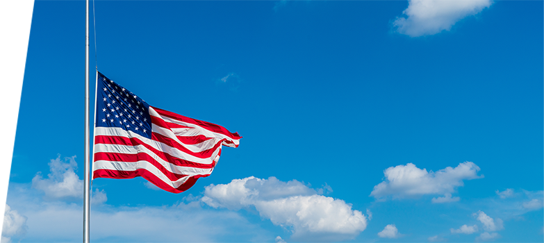 An American flag at half-mast waving in the wind.