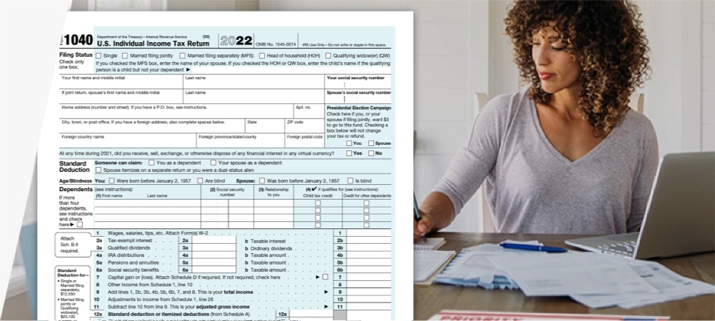 Woman doing taxes with computer, IRS form 1040, and USPS Priority Mail envelope.