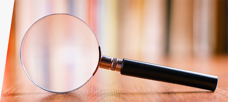 A magnifying glass on a wooden floor.