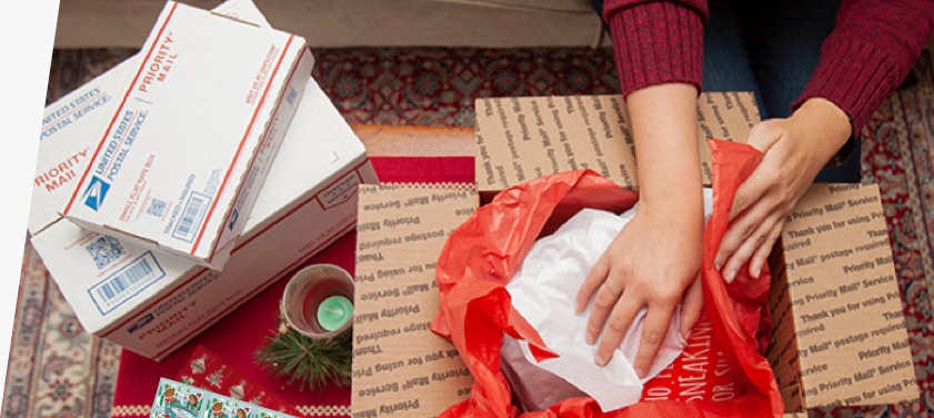 Cajas Priority Mail y estampillas de días festivos para enviar regalos.