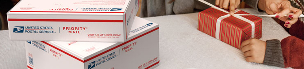 People wrapping holiday gifts they'll ship inside Priority Mail<sup>®</sup> boxes.