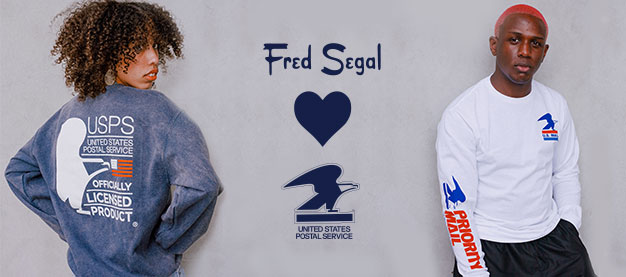 A woman wearing a USPS Sweatshirt and a man wearing a Long Sleeve Priority Mail Shirt from the Fred Segal officially licensed USPS collection.