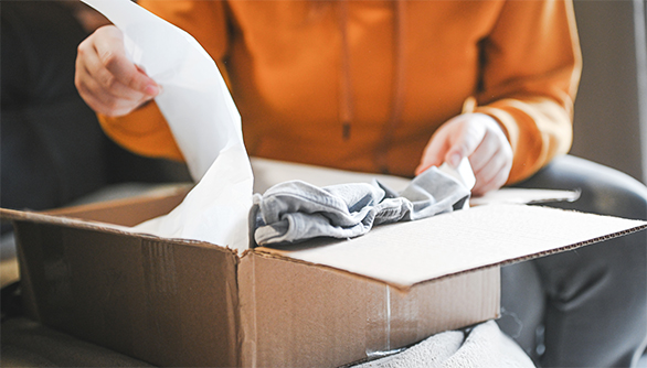 Customer taking items out of an open shipping box.