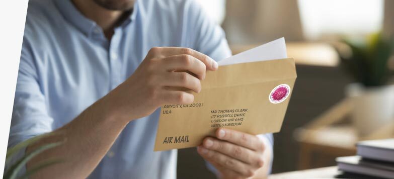 Person preparing to send a letter using First-Class Mail International service.