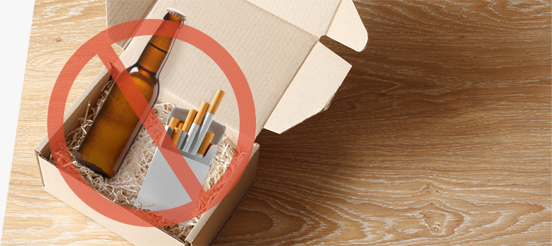 Alcohol and tobacco products in a packing box and crossed out to indicate that they cannot be shipped.