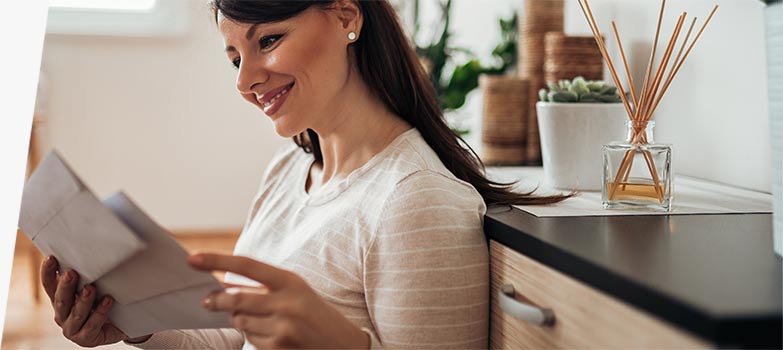 Una mujer mirando cartas de un envío semanal de correo.