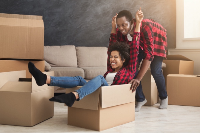 A couple playing together surrounded by moving boxes.