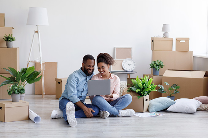 A family sitting amongst moving boxes.