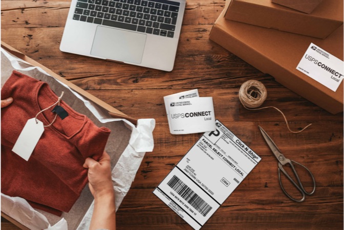 USPS Connect Local labels next to laptop, package, and packing supplies on a table.