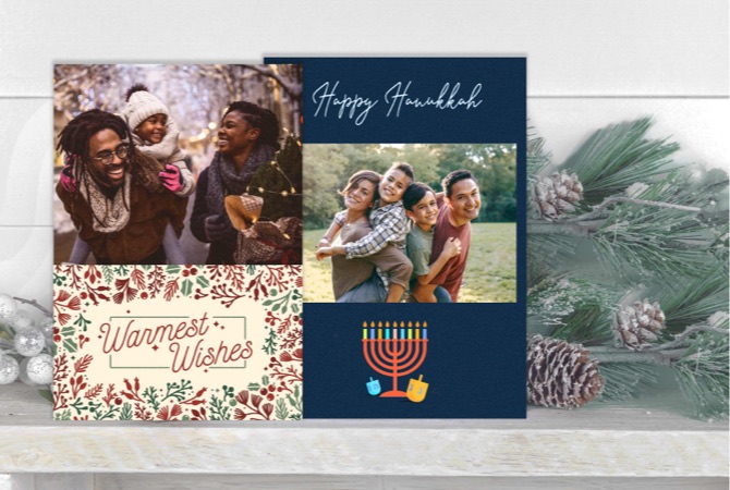 Tarjetas con fotos personalizadas con temas festivos sobre un escritorio junto a una rama de pino nevada.