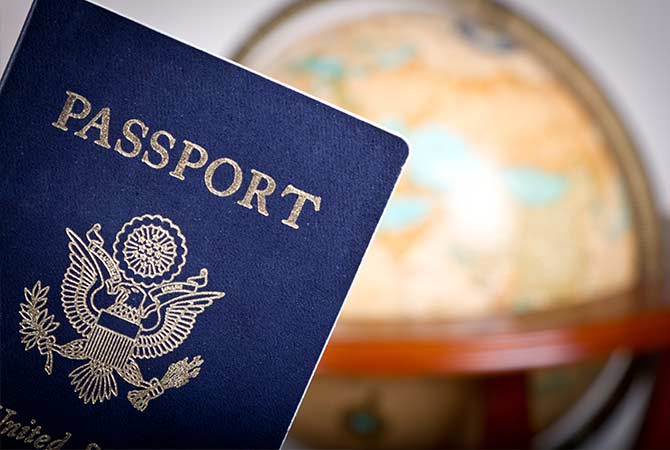 A passport with a world globe behind it.