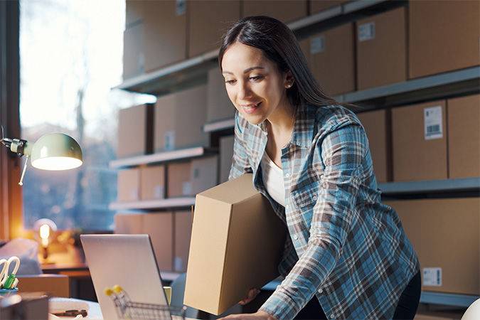 A person standing in front of a shelf of Ground Advantage packages ready to ship.