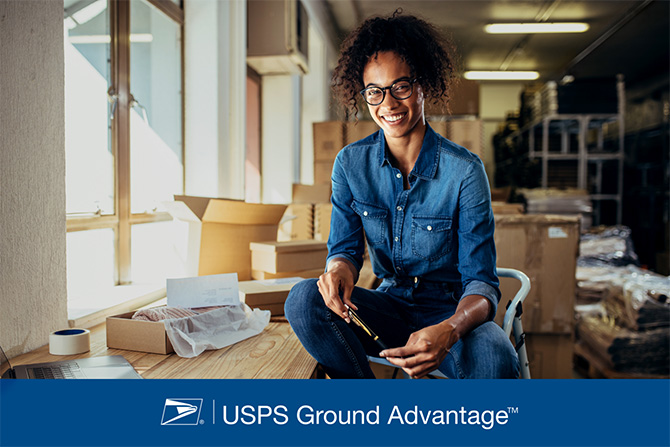 USPS Ground Advantage. Una persona rodeada de cajas de envío.