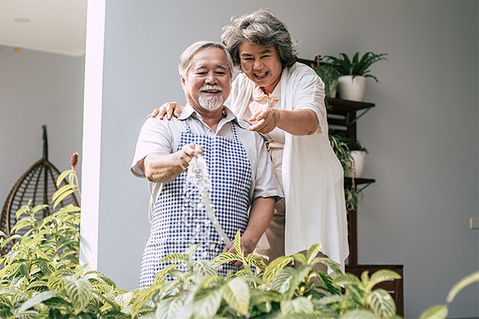 A man and woman watering plants.