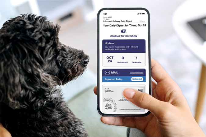 Person holding a dog while looking at an Informed Delivery Daily Digest email on their smartphone.