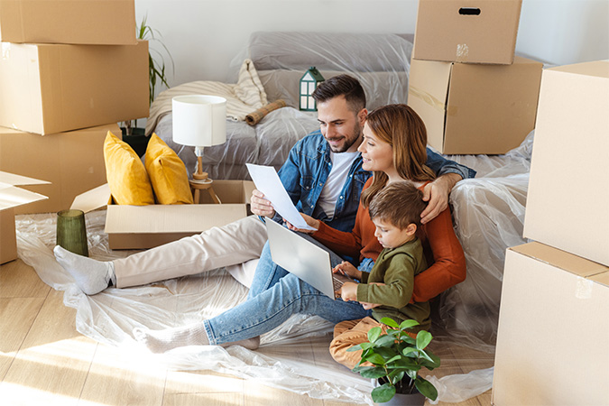 A family sitting together with moving boxes around them.