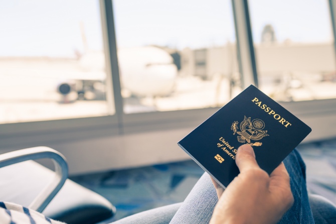 Person holding their passport at an airport.