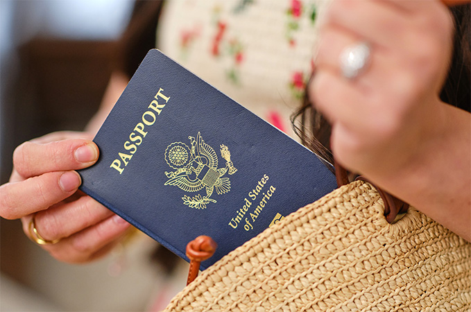 A woman holding up her passport.
