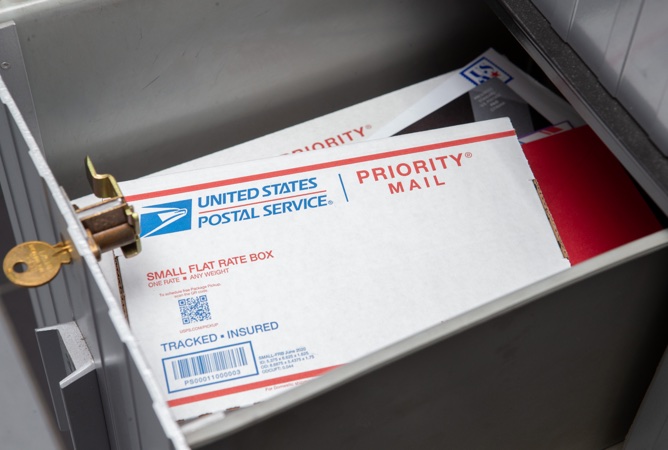 A PO Box with Priority Mail Small Flat Rate box and other mail inside.
