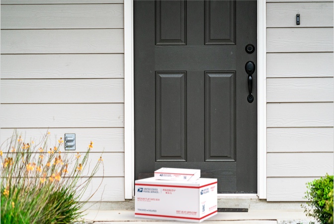 放置在房子门廊等待取件的 Priority Mail 包装盒。