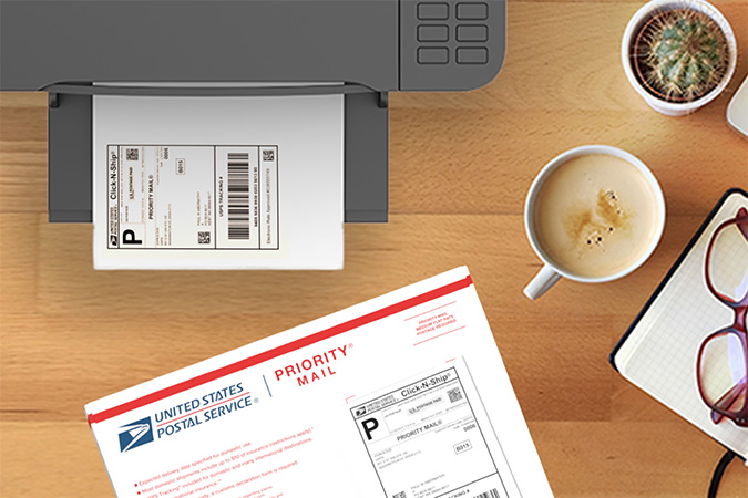 A CNS label waiting in a printer tray beside a Priority Mail envelope.