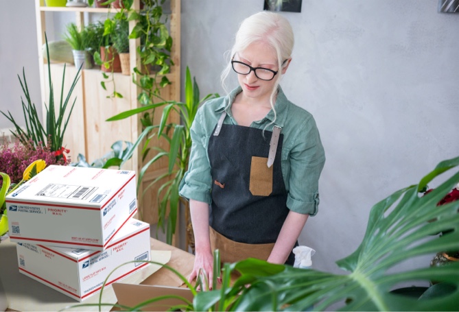 Small business owner with a stack of packages ready for shipment.