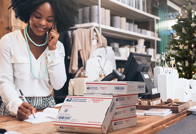 Small business owner with a stack of packages ready for shipment.