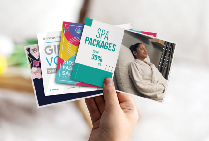 Marketing flyers being held by a person.