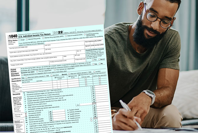 Un formulario 1040 de declaración de impuestos en primer plano con un hombre escribiendo en una mesa en el fondo.