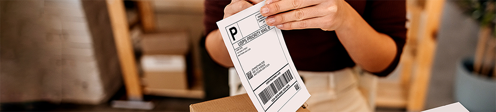 A label printed from the Click-N-Ship service being applied to a package for shipping.