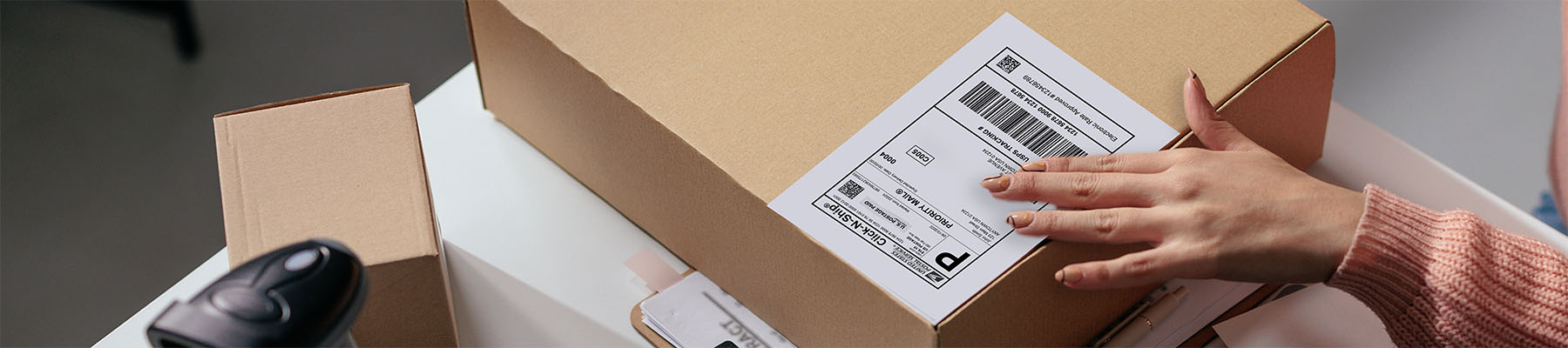 A package with hands putting a label on it.