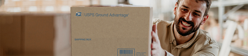 A person placing a USPS Ground Advantage package on a shelf in a delivery center.