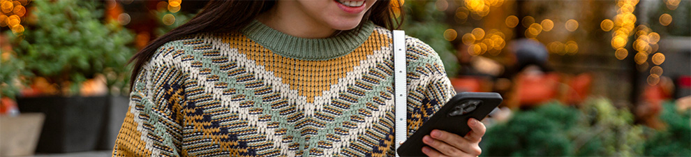 A person in a sweater using the Informed Delivery app on a smartphone.