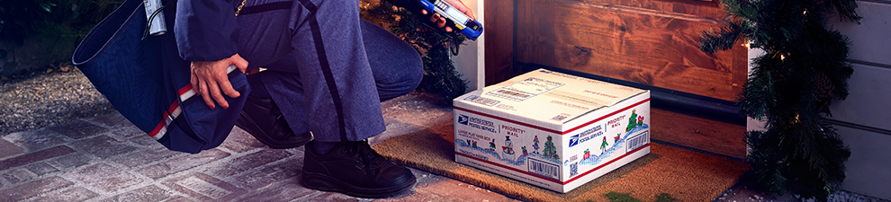 Letter carrier scans a holiday Priority Mail package on a doorstep.