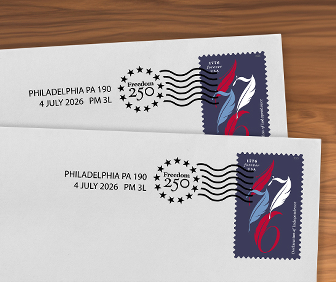Two white envelopes on a table showing the Declaration of Independence stamp with the national cancellation.