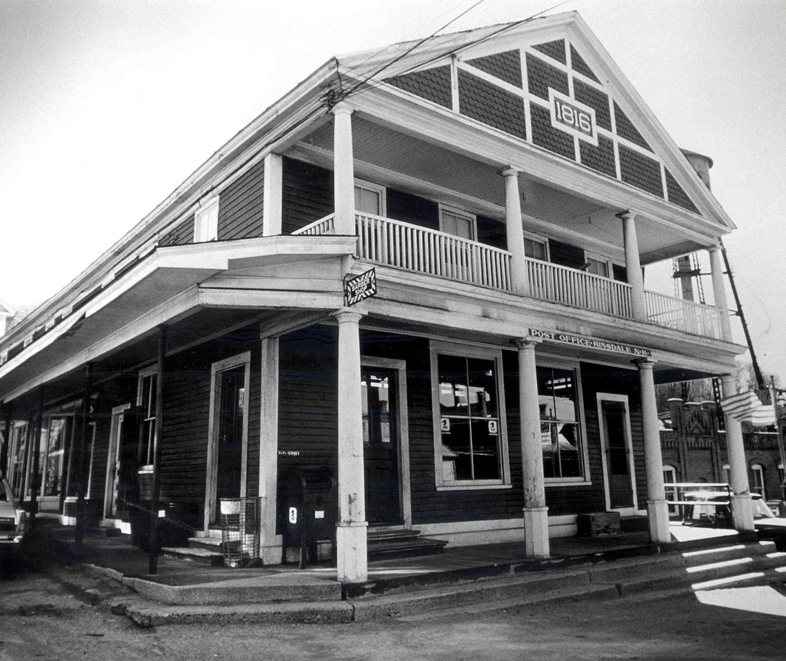 Black and white photography of a two-story Post Office with front porch and balcony.